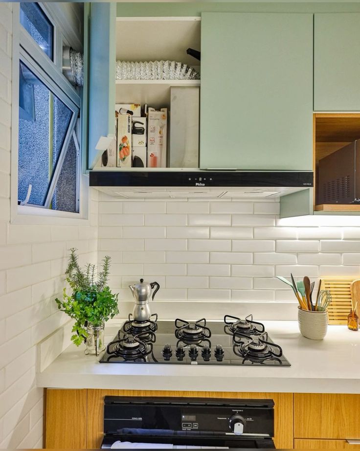 Coifa embutida na marcenaria com detalhe do duto passando por dentro e saindo pela janela