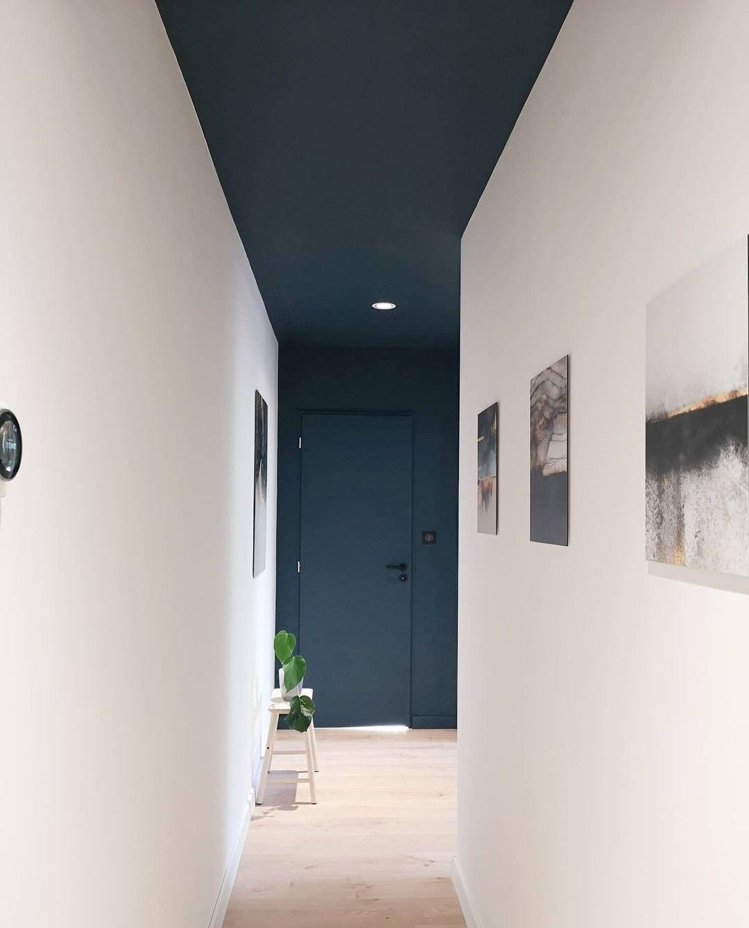 corredor com paredes muito brancas e um teto com uma parede azul secreto
