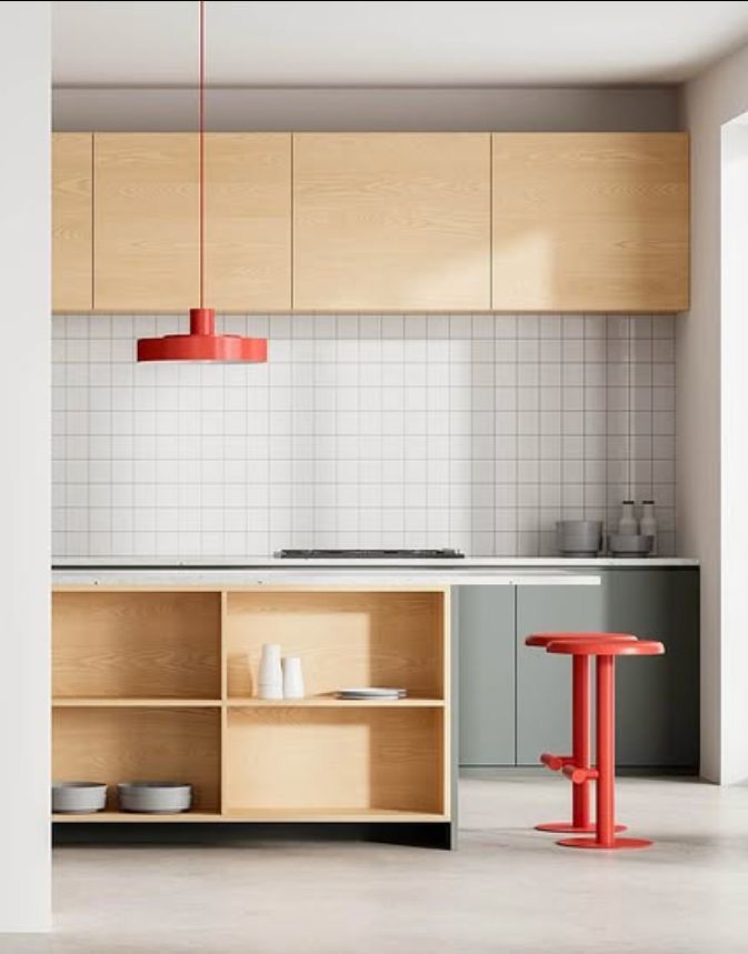 cozinha com tons claros e madeiras suaves e alguns detalhes de banco e luminária em vermelho vivo