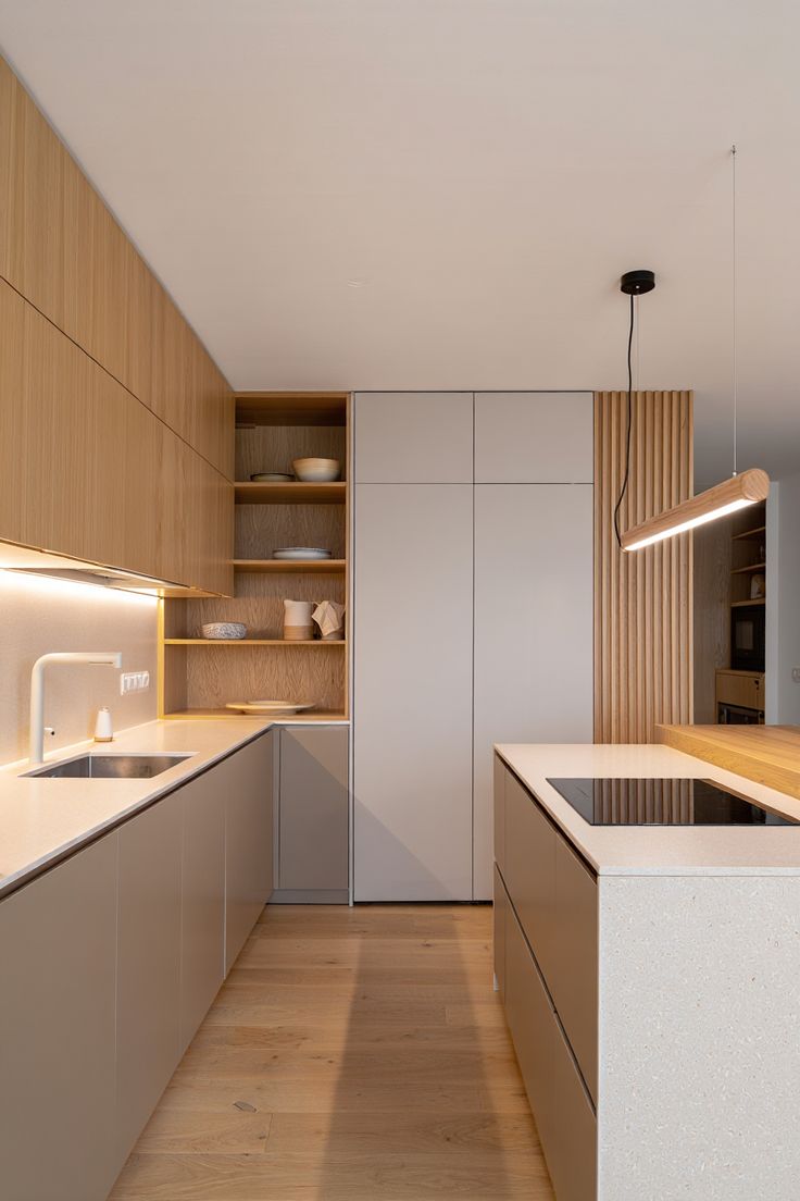 Cozinha em L com marcenaria em madeira clara e tons neutros com painel ripado