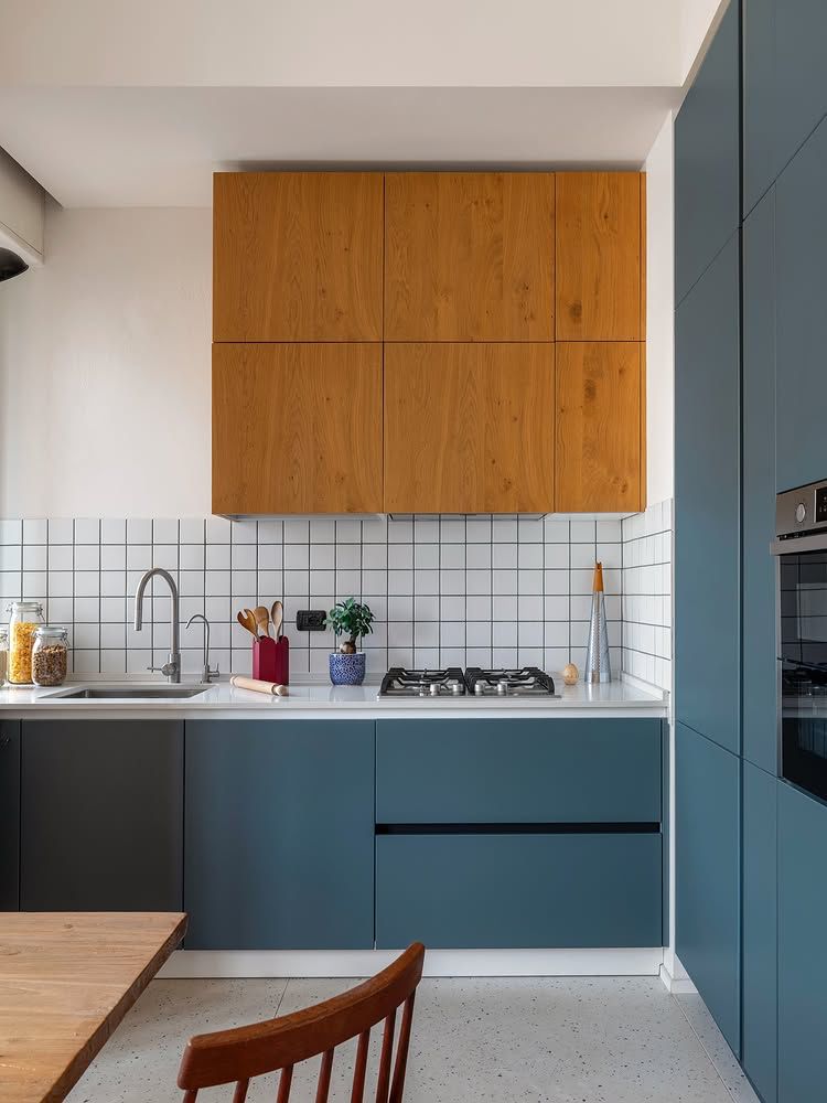 cozinha equilibrando tom de azul nos gabinetes com azulejos e paredes brancas e aréus na cor freijó́