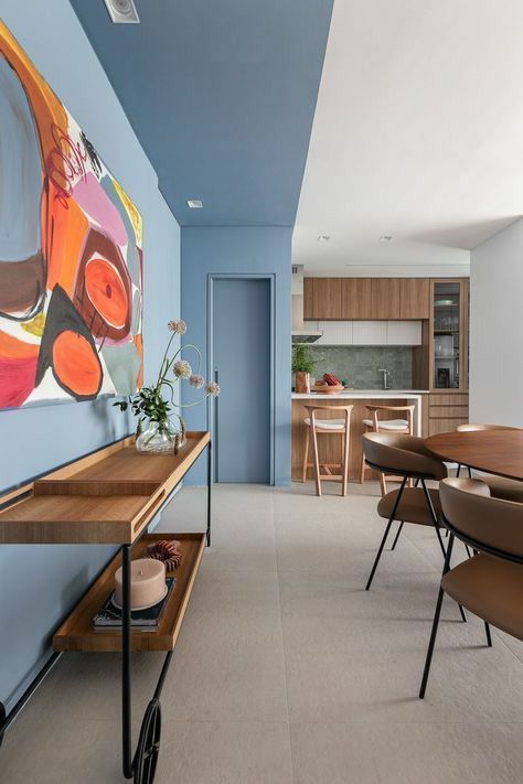 sala e cozinha com tons neutros e uma unica parede no azul